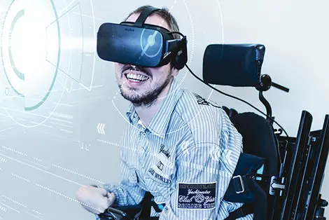 Ein Mann mit VR Brille testet den virtuellen Rollstuhlsimulator WheelSim.