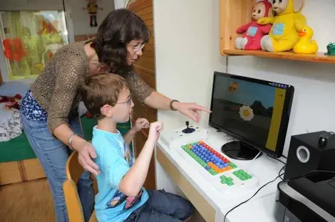 Eine Lehrerin erklärt einem Schüler eine Aufgabe am PC.